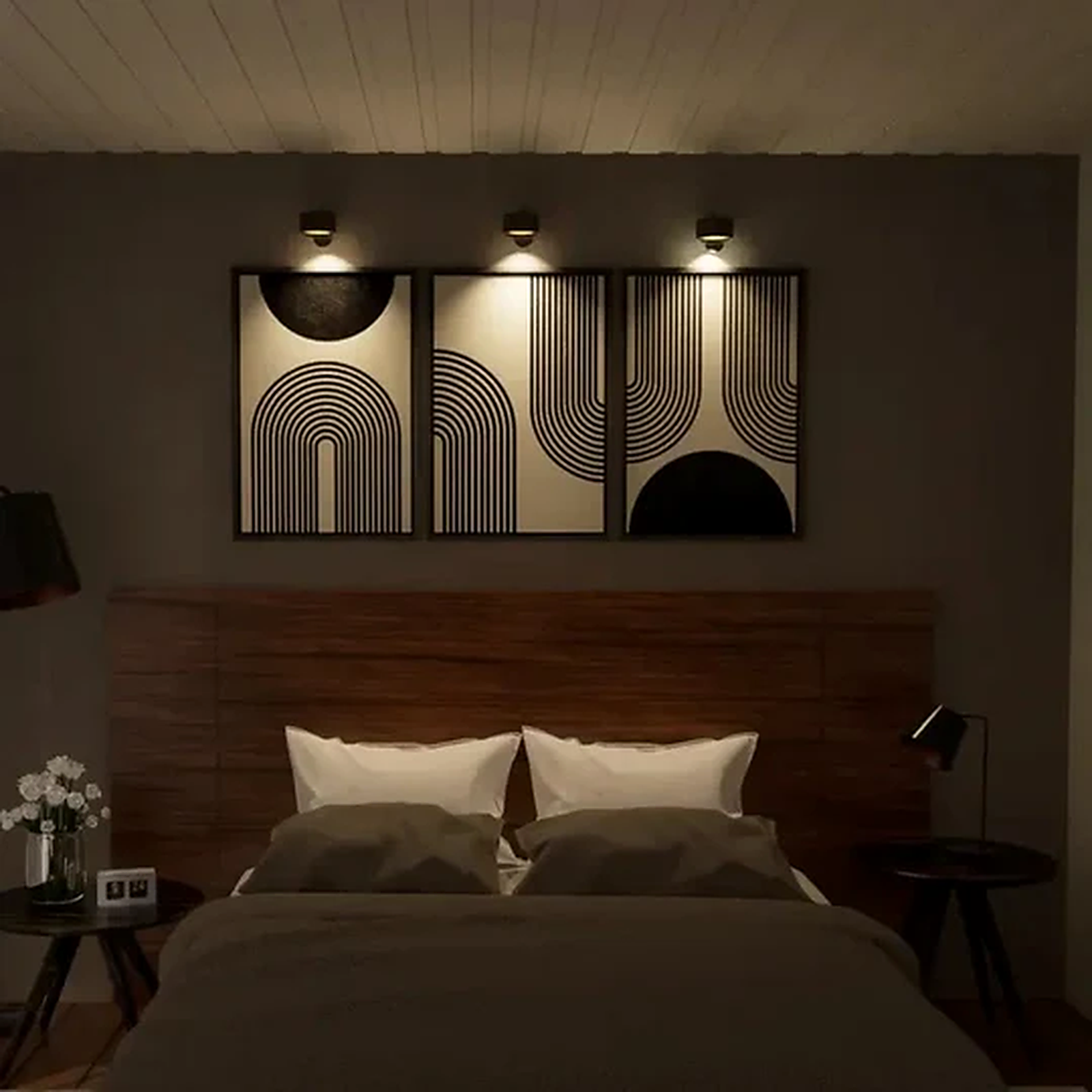 Three battery operated wall sconces lighting framed art above a bed