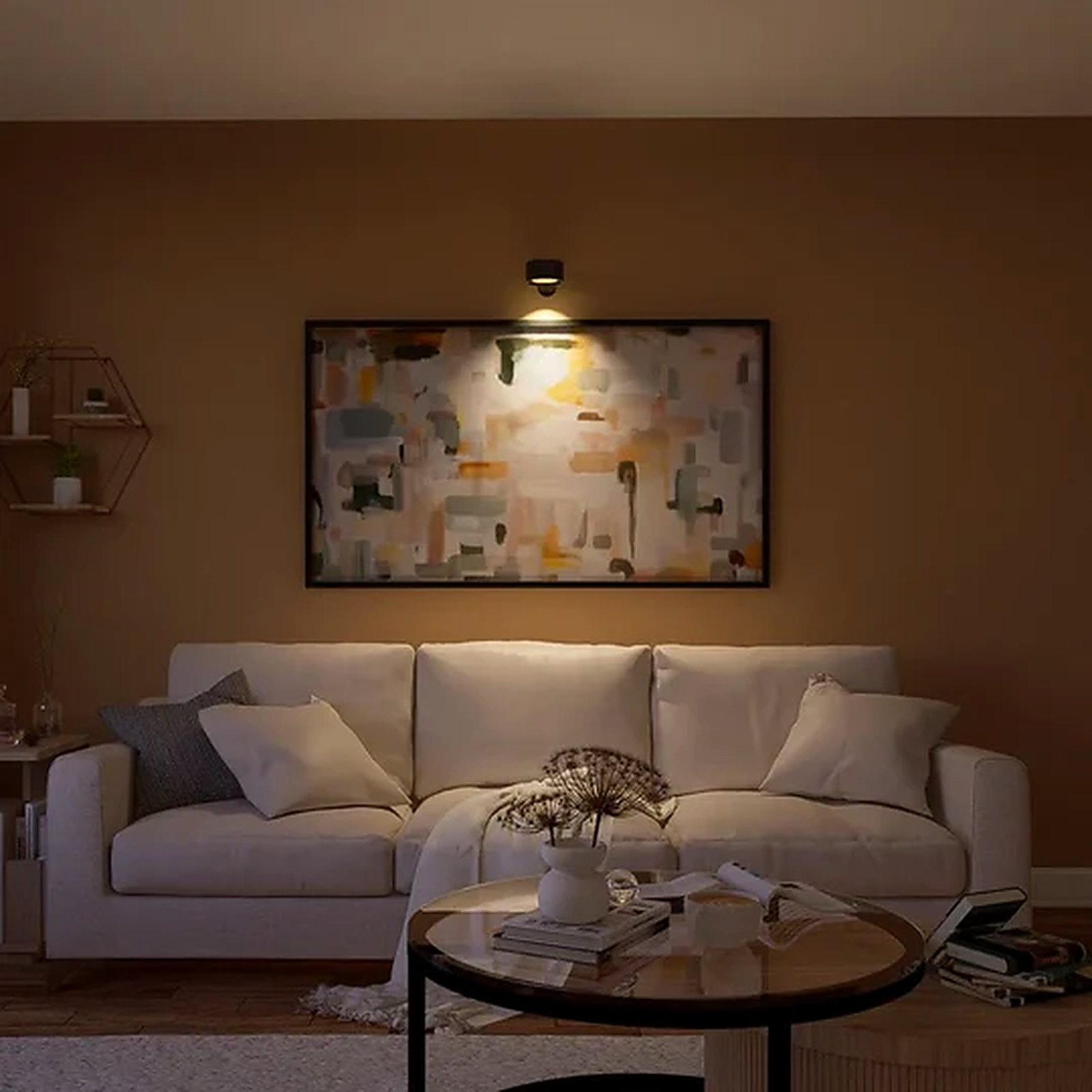Rechargeable wall sconce lighting artwork above a living room sofa