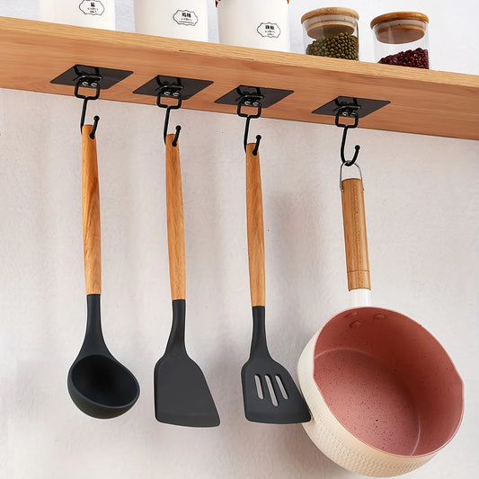 Adhesive wall hooks holding kitchen utensils and a bowl