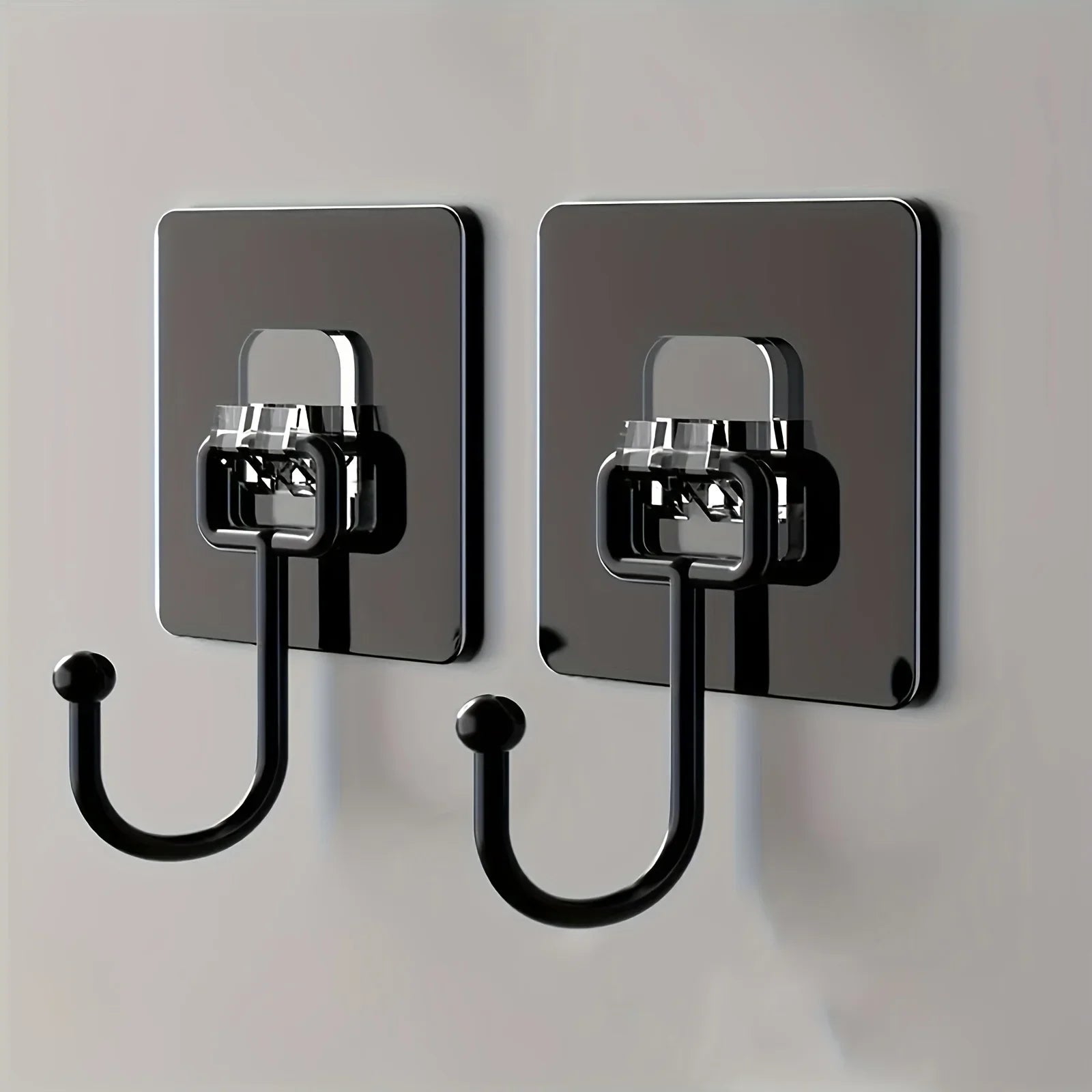 Two black adhesive wall hooks mounted on a wall