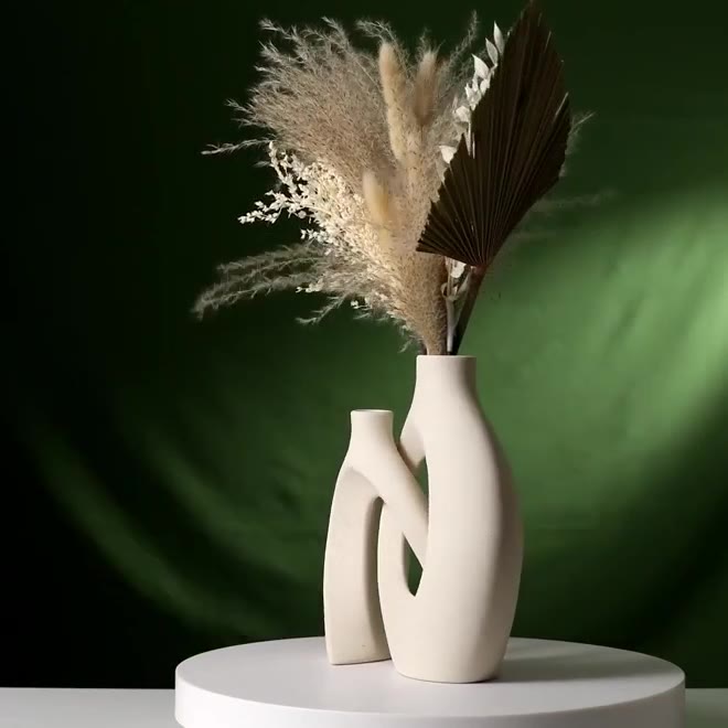 Cream snuggle vase set filmed on a green backdrop, showing both sizes styled with pampas and dried florals