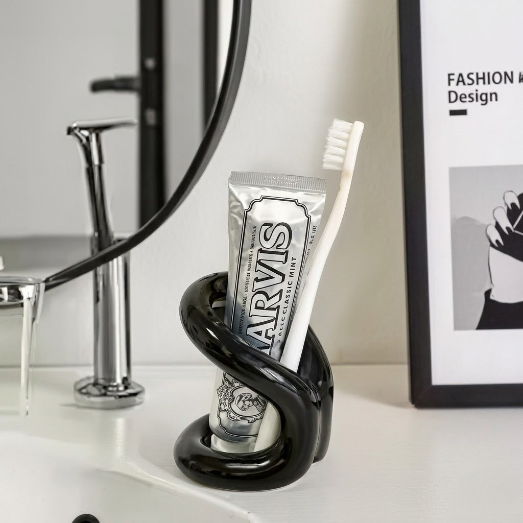 Black knot ceramic toothbrush holder with Marvis toothpaste on a bathroom vanity